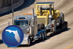 florida map icon and a semi-truck hauling heavy construction equipment