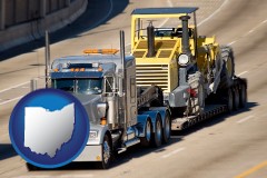 ohio map icon and a semi-truck hauling heavy construction equipment