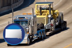 south-dakota map icon and a semi-truck hauling heavy construction equipment
