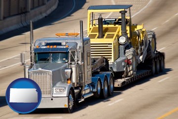 a semi-truck hauling heavy construction equipment - with Kansas icon
