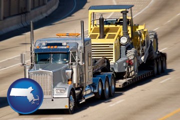 a semi-truck hauling heavy construction equipment - with Massachusetts icon