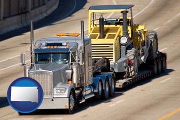 a semi-truck hauling heavy construction equipment - with South Dakota icon